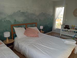 a bedroom with a large bed with white sheets at Chez Chantal in Étables