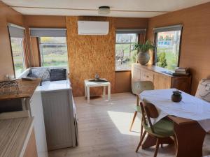 eine Küche und ein Esszimmer mit einem Tisch und Stühlen in der Unterkunft Mobilheim v LVA 1 in Podivín