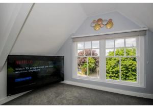 a living room with a large window and a flat screen tv at ALTIDO House in Camborne, Cornwall in Camborne