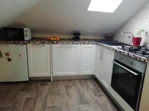a kitchen with white cabinets and a stove top oven at Apartment Felix in Split