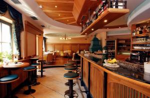un bar con una fila de taburetes en un restaurante en Cityhotel Goldener Adler B&B en Chiusa