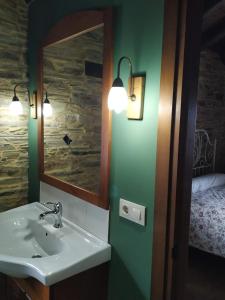 ein Badezimmer mit Waschbecken und Spiegel und einem Bett in der Unterkunft Casa Carballeira in Villarfernando + 37 Fotos