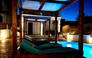une terrasse avec une piscine et une maison dans l'établissement Villa Athina 1st floor, à Nea Kallikratia