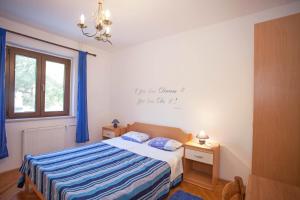 - une chambre avec un lit doté de draps bleus et une fenêtre dans l'établissement Apartments and Room Agata, à Banjole