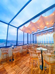 a balcony with tables and chairs on a cruise ship at Zoom Hotel Mulawarman in Samarinda