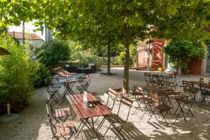a group of tables and chairs under a tree at G&icirc;te d'Etape des Capucins in Le Puy en Velay