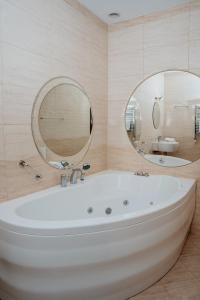 a bathroom with a tub and a large mirror at Hotel Resident in Nowa Sarzyna