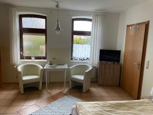 a bedroom with a table and two chairs and a television at Ferienwohnung Hummelhus Elmenhorst in Elmenhorst