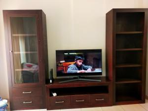 a television in a wooden entertainment center with a cabinet at Apartamento la romanilla a 200metros de la playa in Roquetas de Mar