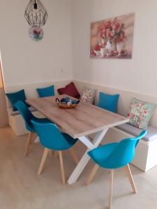 a dining room table with blue chairs in a room at Central Apartment Near The beach with huge private terrace in Loutraki