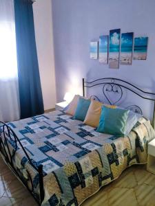 a bedroom with a bed with a quilt on it at Appartamento con giardino in Lampedusa