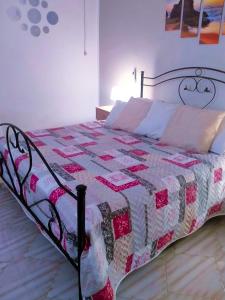 - un lit avec une couette dans une chambre dans l'établissement Appartamento con giardino, à Lampedusa