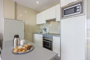 a kitchen with a stove, microwave, and dishwasher at Klayman Diamond Aparthotel in Acantilado de los Gigantes