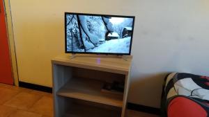 una TV a schermo piatto seduta sopra un tavolo di GRAYNITE-High Altitude Apartment a Passo del Tonale