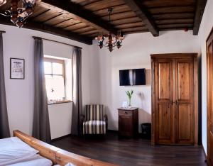 a bedroom with a bed and a tv on the wall at Zsindelyes Cottage in Érpatak