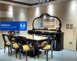 a black dining room table with chairs and a mirror at Maadi Apartment - 3 rooms ( Families Only ) in Cairo