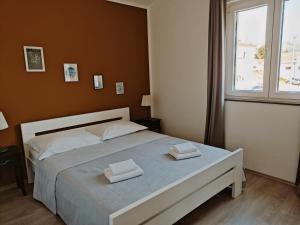 a bedroom with a bed with two towels on it at Apartmani Luka in Grebaštica