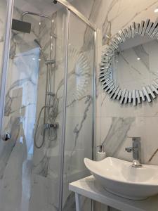 a bathroom with a sink and a shower with a mirror at Pokoje Gościnne Akwatel in Jastarnia +47 photos