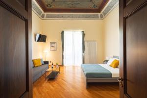sypialnia z łóżkiem, kanapą i oknem w obiekcie Open Sicily Homes "Residence ai Quattro Canti" - Self check in - Deposito Bagagli w mieście Palermo