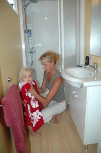 a woman sitting on the floor with a child in a bathroom at Casa mobile - Bella Austria**** in Sankt Peter am Kammersberg