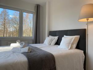 1 dormitorio con 2 camas con sábanas blancas y ventana en Pokoje Gościnne Akwatel, en Jastarnia