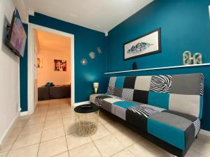 een woonkamer met een bank en een blauwe muur bij REPUBLIQUE CENTRE Nouvelle Gestion et Ménage 2024 in Carcassonne
