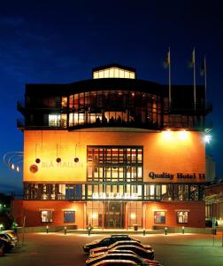 un bâtiment avec beaucoup de fenêtres la nuit dans l'établissement Quality Hotel 11 & Eriksbergshallen, à Göteborg