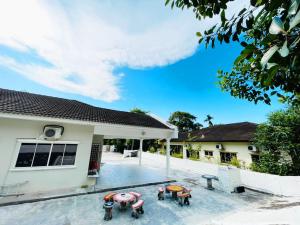 une maison avec une terrasse dotée de tables et de chaises dans l'établissement Pd Villa Holiday, à Port Dickson