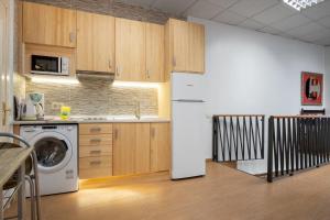een keuken met houten kasten en een witte koelkast bij 2 bedrooms 1,5 bathrooms furnished - Malasaña - Cozy & Vintage - Minty Stay in Madrid