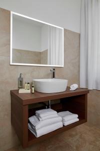 a bathroom with a sink and a mirror and towels at Hotel Spigamonti in Negrar