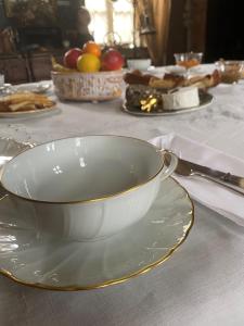 eine weiße Schüssel auf einem Teller auf einem Tisch in der Unterkunft La Demeure du Collectionneur in Quintin