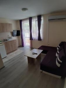 ein Wohnzimmer mit einem Sofa und einem Tisch in der Unterkunft Guest House Diamandievi in Nessebar