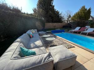 a backyard with a couch and a swimming pool at Gite Villa Avril piscine- jacuzzi- sauna - 15 Pers-proche Europapark in Sélestat