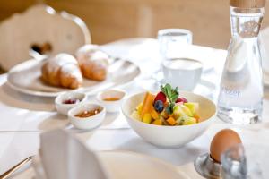 einen weißen Tisch mit einer Schale Obst und Gebäck in der Unterkunft Hotel Schmuckhof in Klausen