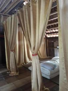 ein Himmelbett mit Vorhängen in einem Zimmer in der Unterkunft Homestay Nguyễn Huệ in Làng Mõ