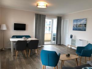 un soggiorno con tavolo e sedie blu di Hafen 15 - Ihre Ferienwohnung am Hainer See bei Leipzig a Neukieritzsch