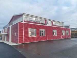 a red building in a parking lot at Hótel Grindavik in Grindavík
