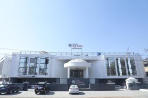 a building with cars parked in front of it at HOTEL KEWAL in Nashik