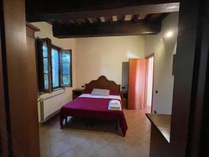 um quarto com uma cama com um cobertor roxo em Residenza Il Falchetto em Assis