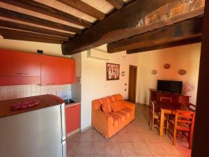 uma cozinha com um sofá laranja e uma mesa em Residenza Il Falchetto em Assis