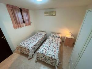 a bedroom with two beds and a night stand with a lamp at Ammiraglio Giglio Castello in Isola del Giglio