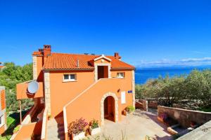 an orange house with a view of the ocean at Apartments Sea Line in Prigradica