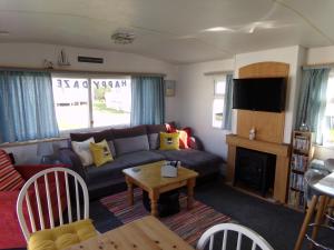 a living room with a couch and a table at Happydaze Caravan in Bacton