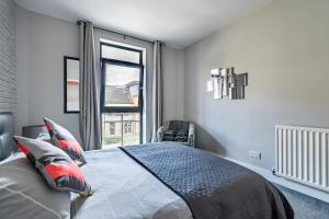 a bedroom with a bed and a large window at amazing apartments - Hopetoun Street near The Playhouse in Edinburgh