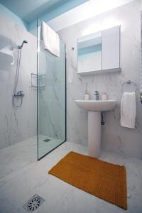 a bathroom with a sink and a glass shower at Eden Sunflower - Luxurious Apartment with Sea View in Rhodes Town