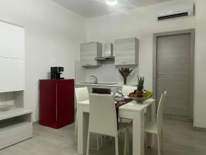 uma cozinha com uma mesa e um frigorífico vermelho em Le Case di Lory em Lecce