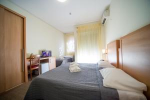 a hotel room with a bed and a desk and a computer at Hotel Foresteria in Volterra