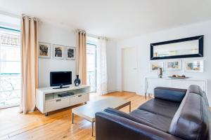 een woonkamer met een bank en een tv bij Condessa Central Duplex in Lissabon