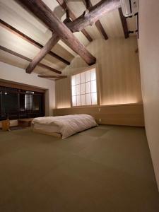 ein großes Schlafzimmer mit einem Bett und einem Fenster in der Unterkunft 城崎温泉 小宿 紬 tsumugi in Toyooka