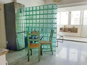 una mesa y sillas en una habitación con una pared de cristal en Triana Boho Azotea - ático La Galatea, en Sevilla